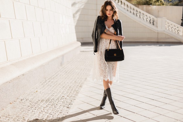 young-stylish-woman-walking-street-fashionable-outfit-holding-purse-wearing-black-leather-jacket-white-lace-dress-spring-autumn-style-posing-high-leather-boots_285396-6747